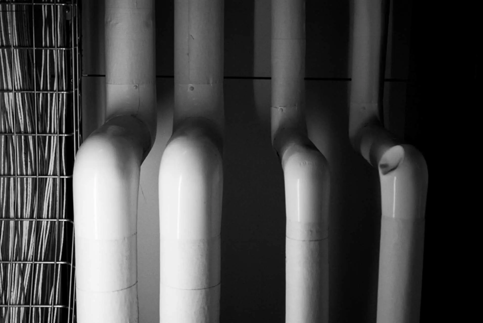 Black and white photo showing four symmetrical white pipes from above